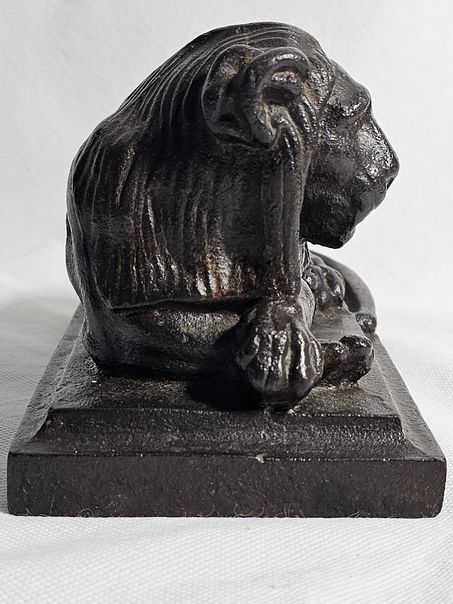 A Cast Iron Sculpture of a Recumbent Lion, on a Rectangular Base,