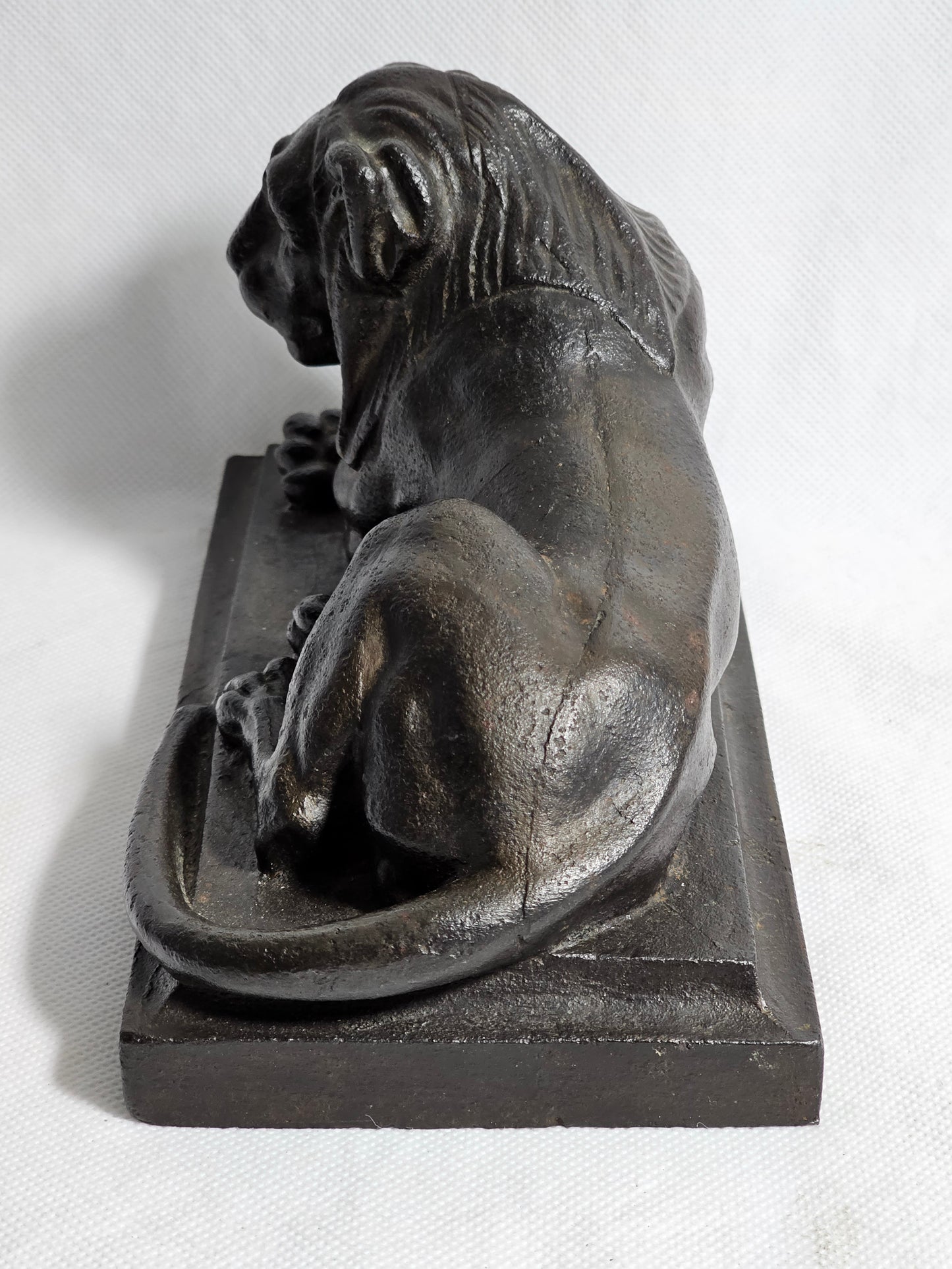 A Cast Iron Sculpture of a Recumbent Lion, on a Rectangular Base,