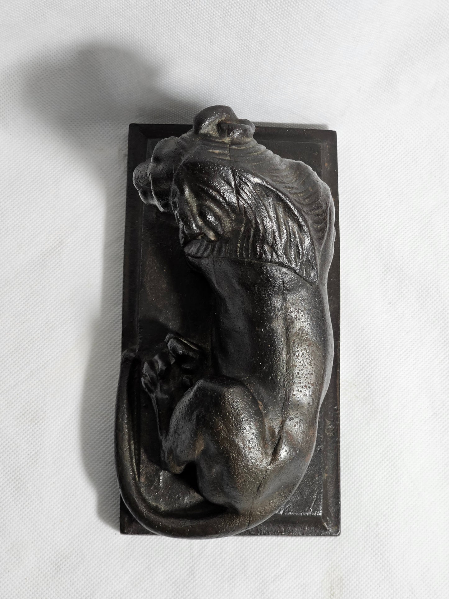 A Cast Iron Sculpture of a Recumbent Lion, on a Rectangular Base,