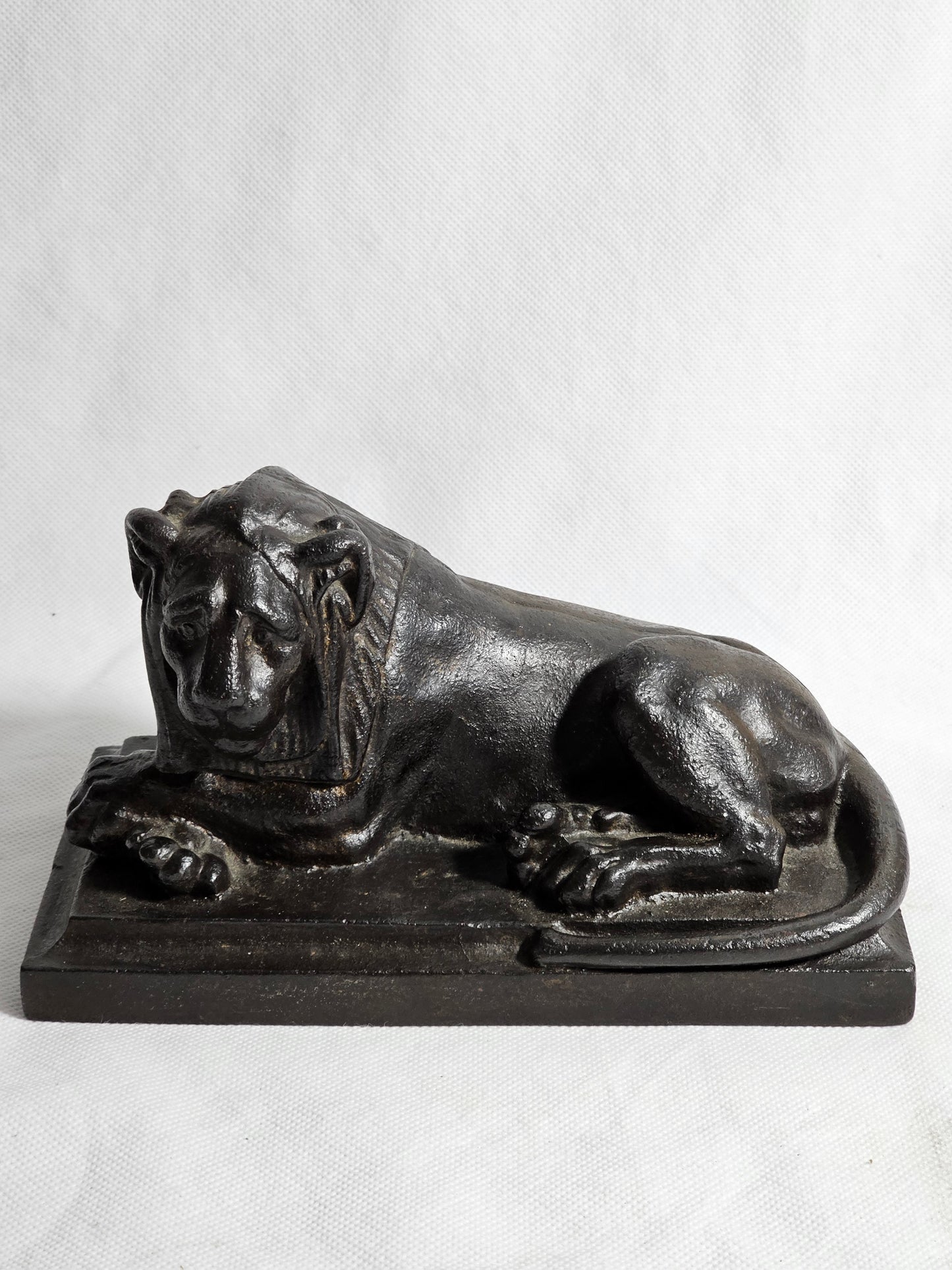 A Cast Iron Sculpture of a Recumbent Lion, on a Rectangular Base,