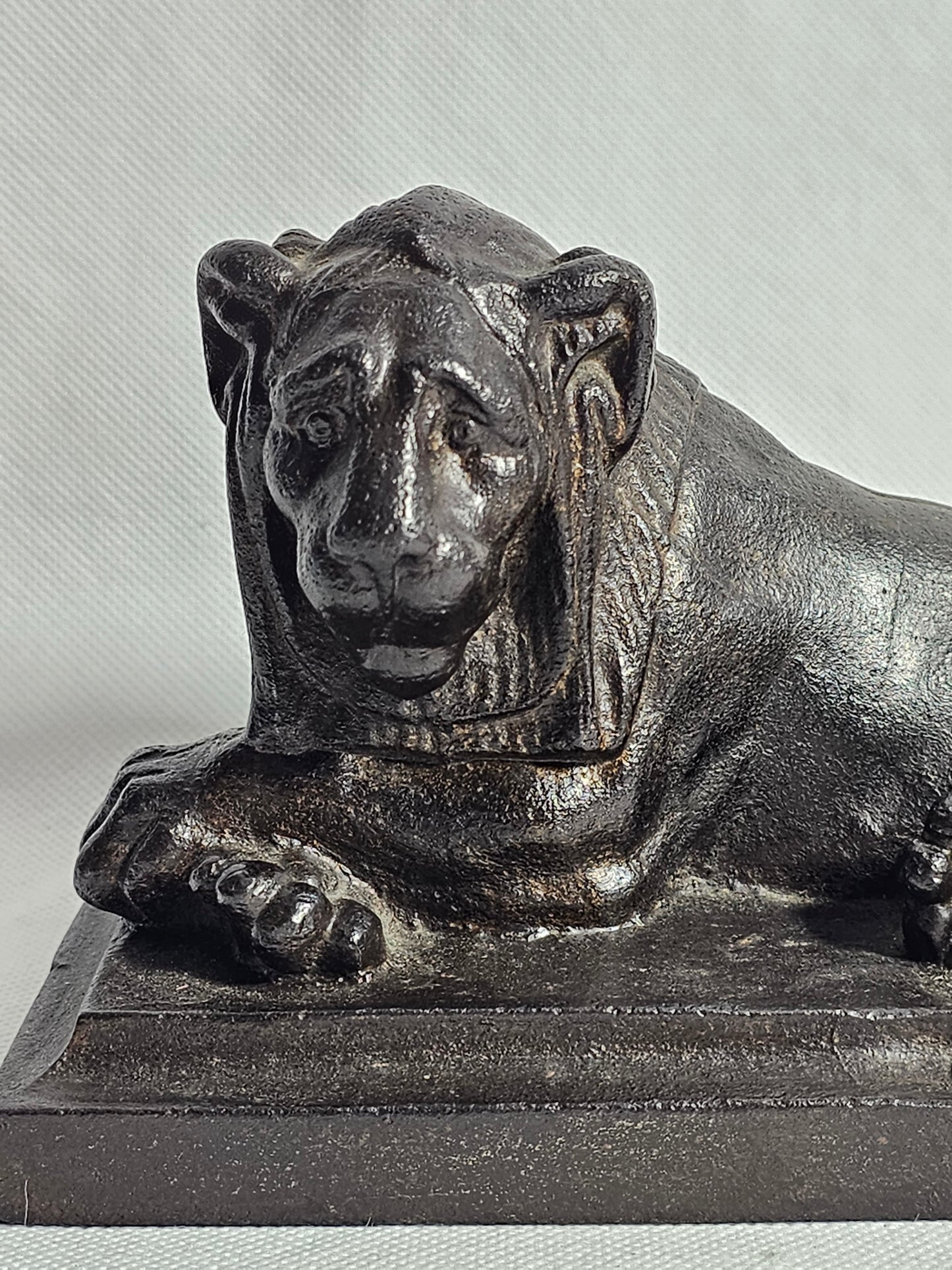 A Cast Iron Sculpture of a Recumbent Lion, on a Rectangular Base,