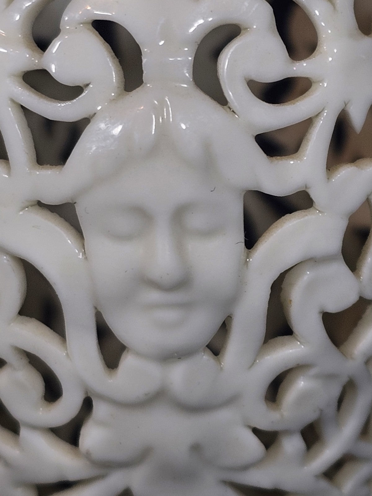 An Antique White Porcelain Grainger Vase Reticulated with Faces on 3 Fish Feet