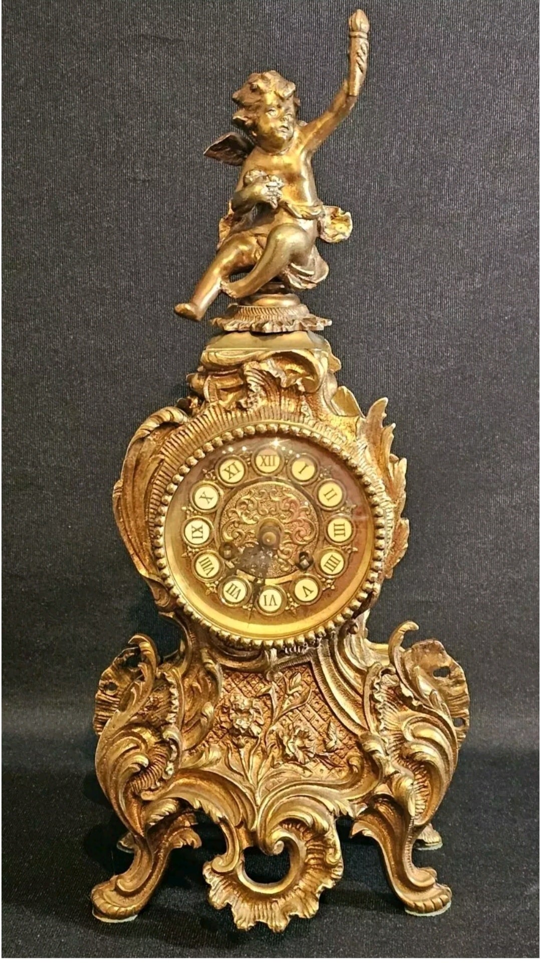 A Louis XV Style Brass Mantle Clock, Mounted with a Cherub, the Dial with Enamel