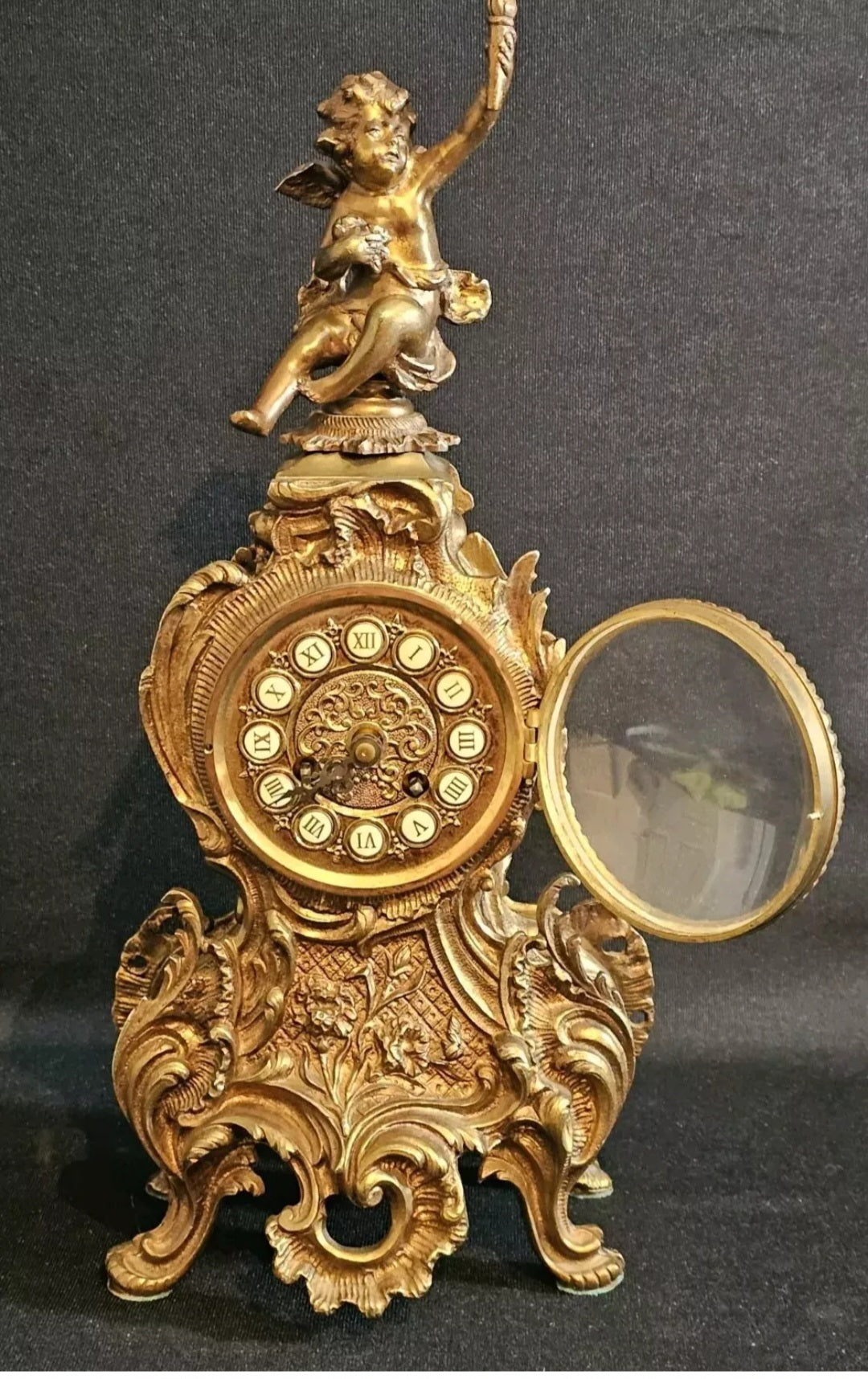 A Louis XV Style Brass Mantle Clock, Mounted with a Cherub, the Dial with Enamel